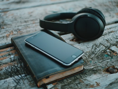 太空灰色iphone6上的书靠近黑色无线耳机